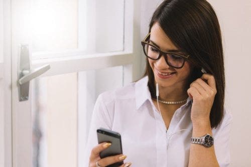 A nurse listens to a nursing podcast using her smartphone.