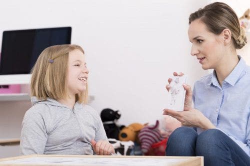 Therapist treating young patient using picture cards