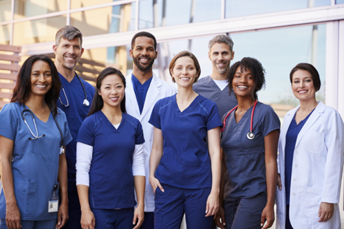 Nurses and nurse practitioners gather together wearing their whitecoats and scrubs