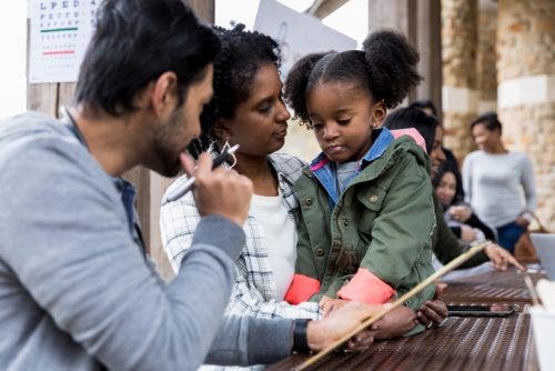 A nurse interviews a parent and child at a rural health clinic.