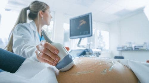 Nurse practitioner does ultrasound on pregnant patient.