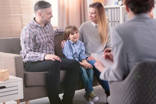 Family in a group therapy session smiling together.
