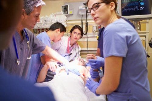 A medical team works on a patient in the emergency room.