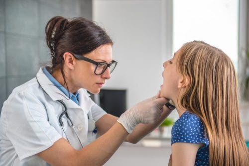 A nurse practitioner examines a young patient.