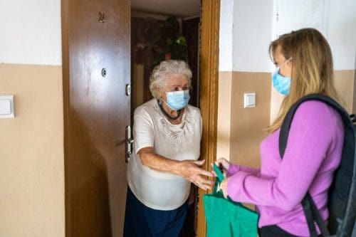 A community social worker assists an elderly resident during the COVID-19 pandemic