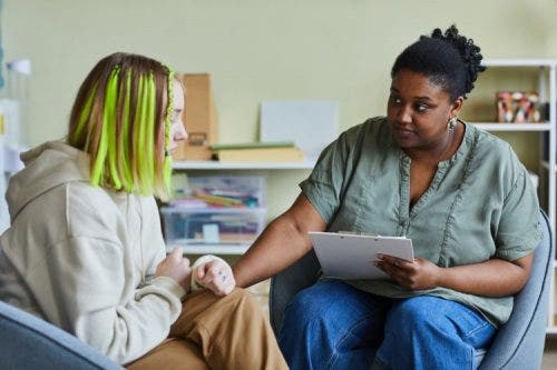 A mental health social worker provides counseling to a student at school.
