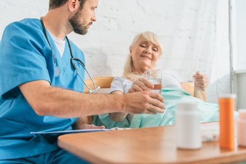 Nurse practitioner gives patient her daily medication.