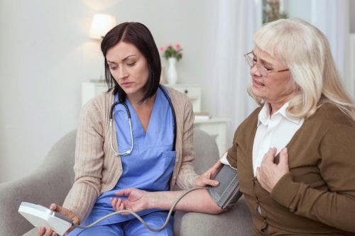A nurse takes an elderly woman’s blood pressure.