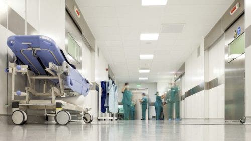 Nurse practitioners working in a hospital corridor.