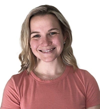 Smiling headshot of Katie, a woman with shoulder-length blonde hair, wearing a peach colored t-shirt.