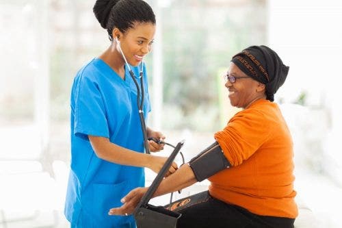 A nurse practitioner uses a blood pressure cuff to test a patient’s blood pressure.