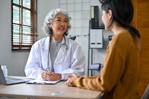 A nurse practitioner consults with a patient in an office.