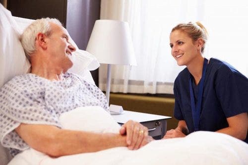 A nurse at the bedside of an elderly patient