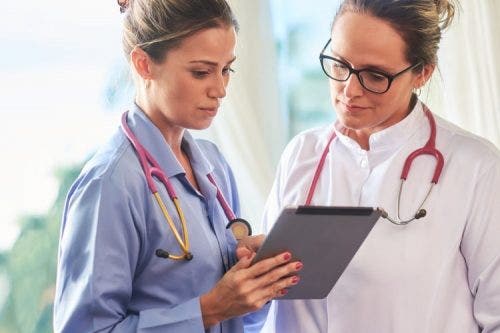 Advanced practice nurses discuss a patient’s chart.