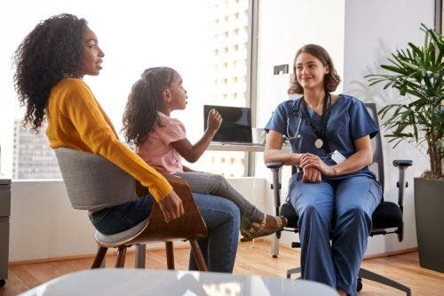 A mother and her young daughter meet with a family nurse practitioner.