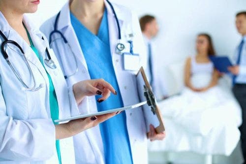 Two healthcare professionals looking at a tablet device in a hospital