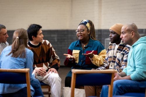 A social worker leads a group discussion at a community center.