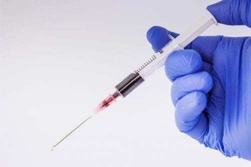 Doctor nurse practitioner holding syringe
