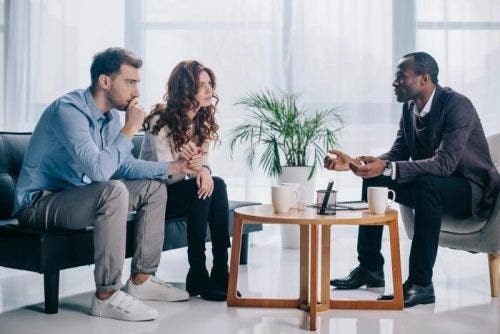 Young couple sitting on a couch across from a professional man.