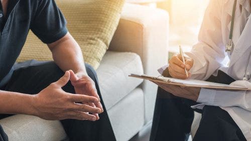 A counselor speaks with a distressed patient.