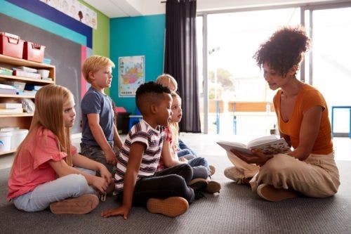 A mentor reads to a group of children.