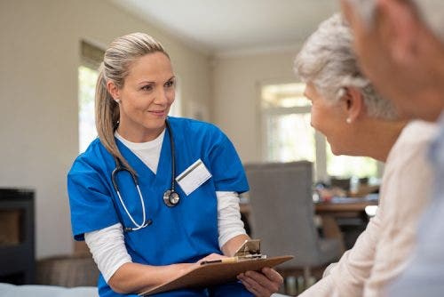 A nurse with a clipboard consults with patients