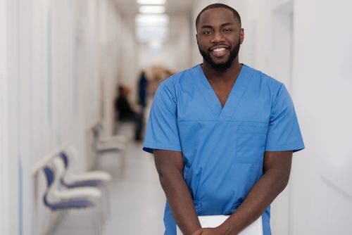 Nurse Leader who holds their DNP poses in a hospital hallway.