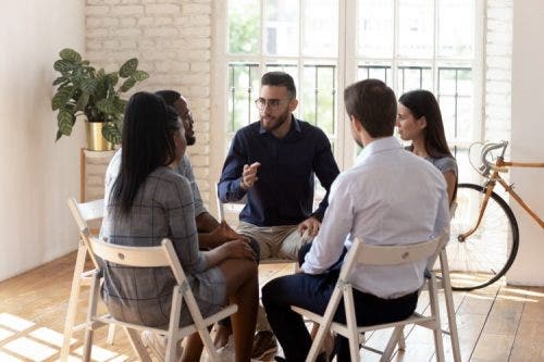 A counselor leads a group therapy session.