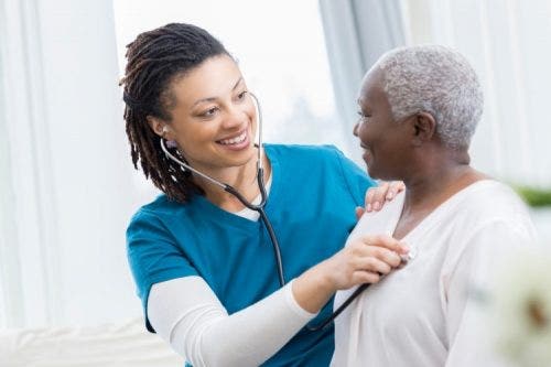 A nurse listens to a patient’s heart with a stethoscope