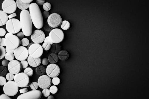 Pills scattered on black background