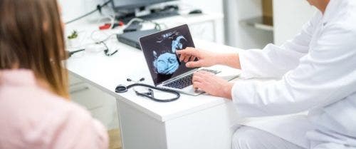 A nurse practitioner shows an ultrasound image to a patient.