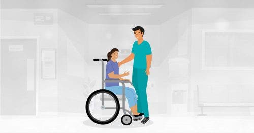 A nurse greets a patient in a wheelchair