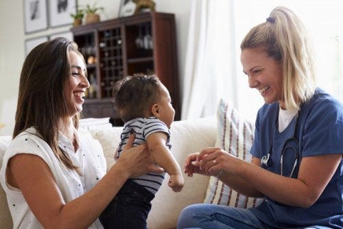 Nurse visiting with baby and mother for health checkup