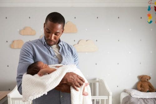 A parent soothes an infant wrapped in a blanket.